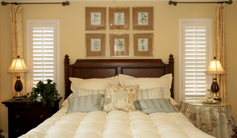 Bedroom with two tall plantation shutters on either side of bed in Minneapolis 